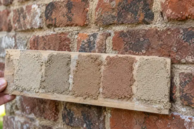 Mortar color samples held against old brick for matching